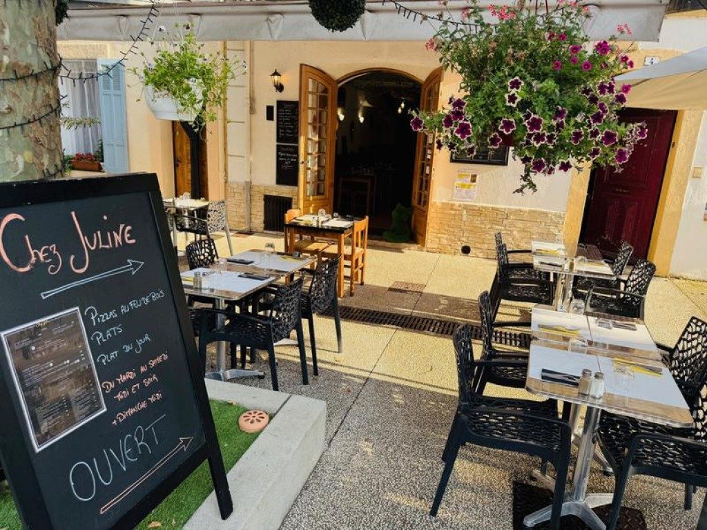 L'ardoise « Chez Juline » à l'entrée, tables dressées sur la terrasse